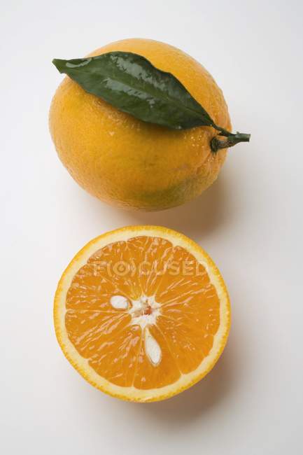 Oranges entières et coupées en deux — Photo de stock