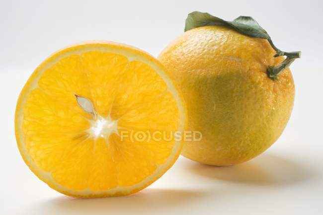 Naranjas enteras y cortadas en rodajas - foto de stock