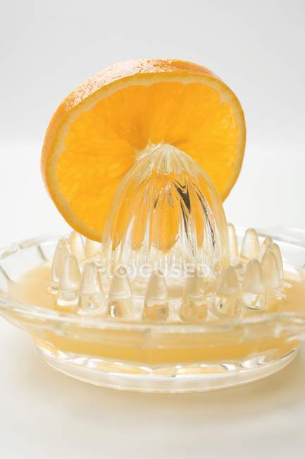 Кусок апельсина на цитрусовом сжимателе — стоковое фото
