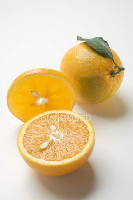 Naranjas enteras y cortadas en rodajas - foto de stock