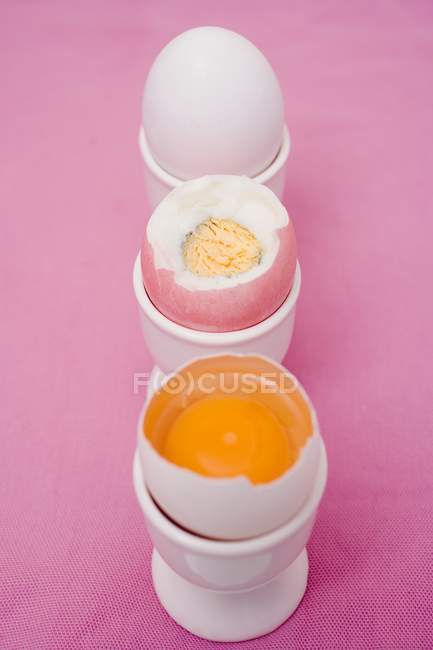Trois œufs dans des tasses à œufs — Photo de stock