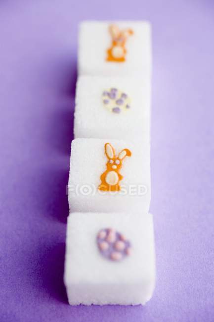 Vue rapprochée des cubes de sucre avec décorations de Pâques dans une rangée — Photo de stock