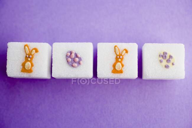 Closeup top view of sugar cubes with Easter decorations in a row — Stock Photo