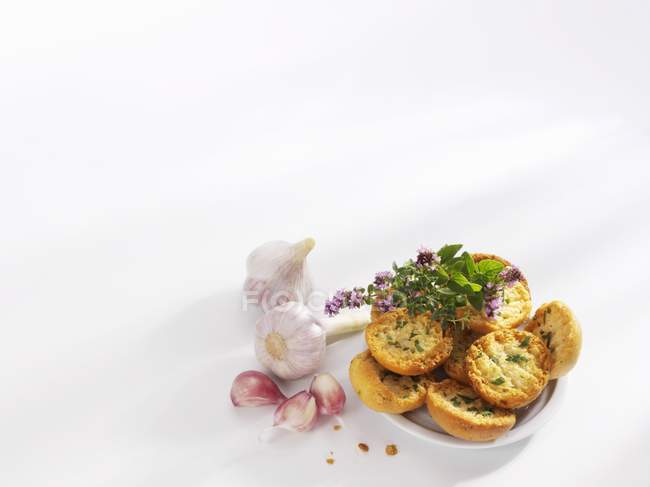 Elevated view of garlic rolls with herbs on white surface — Stock Photo