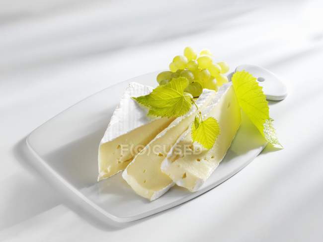 Brie rebanado con uvas - foto de stock