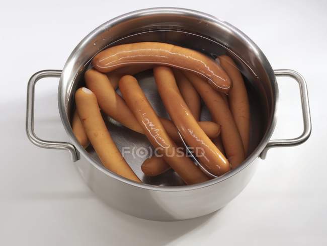 Frankfurters flottant dans une casserole — Photo de stock