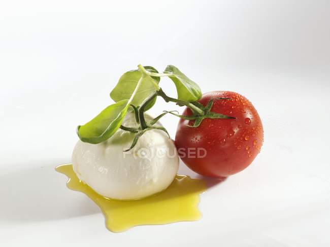 Tomato with mozzarella and basil — Stock Photo