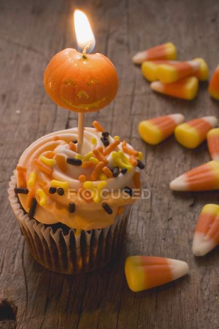 Cupcake con vela de calabaza - foto de stock