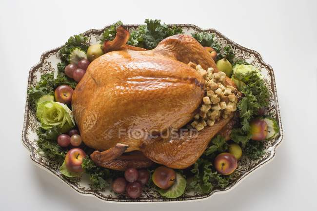 Stuffed turkey on platter with vegetables — Stock Photo