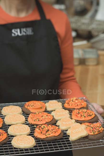 Donna che tiene biscotti di Halloween — Foto stock