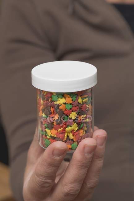 Hand holding a pot of sprinkles — Stock Photo