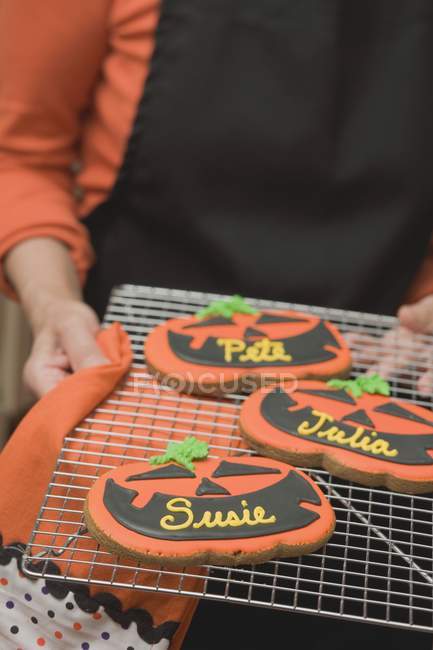 Mani che tengono i biscotti di Halloween — Foto stock