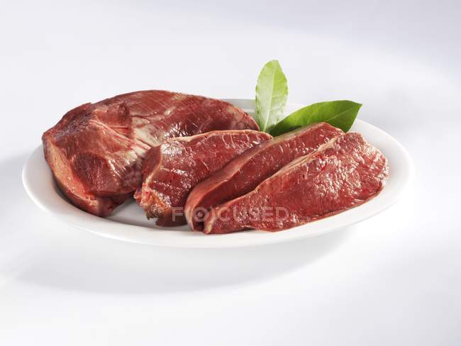 Coração de carne fatiada com folhas de louro — Fotografia de Stock