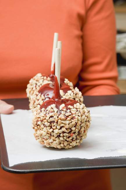 Toffee apples with chopped nuts — Stock Photo
