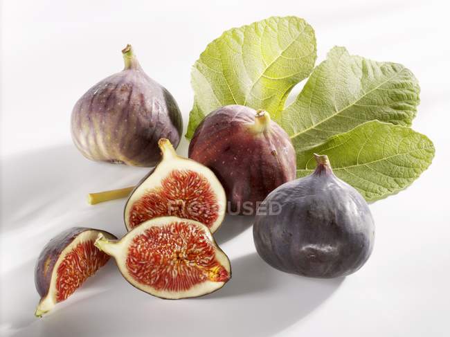 Fresh figs with slices and leaf — Stock Photo