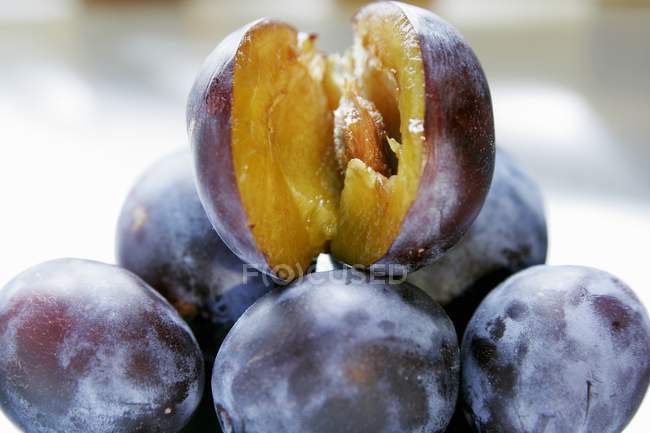 Heap of fresh and halved damsons — Stock Photo