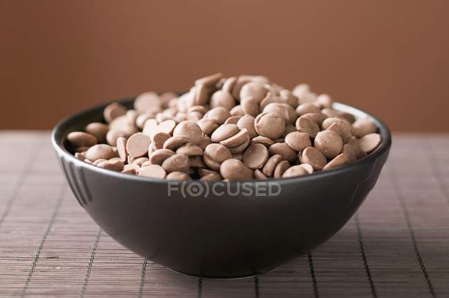 Шоколадні чіпси в коричневій мисці — стокове фото
