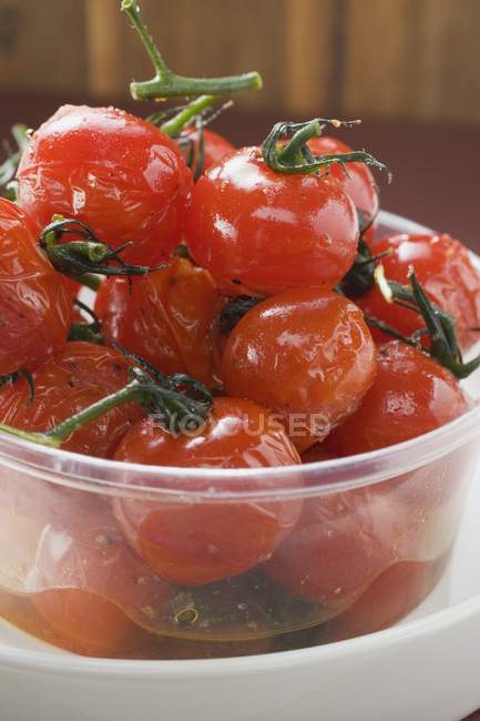 Roasted cherry tomatoes in plastic bowl — Stock Photo