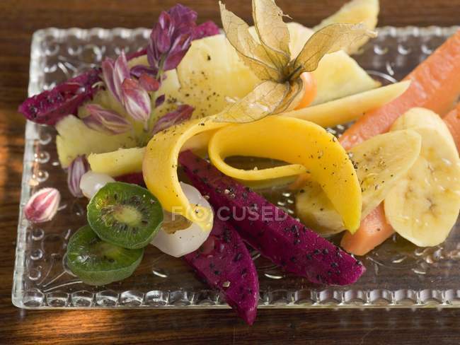 Primo piano vista di macedonia di frutta esotica sul piatto di vetro — Foto stock
