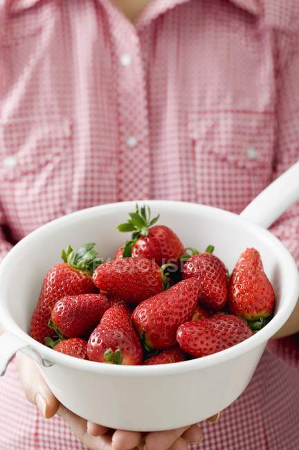 Woman holding strainer with strawberries — Stock Photo