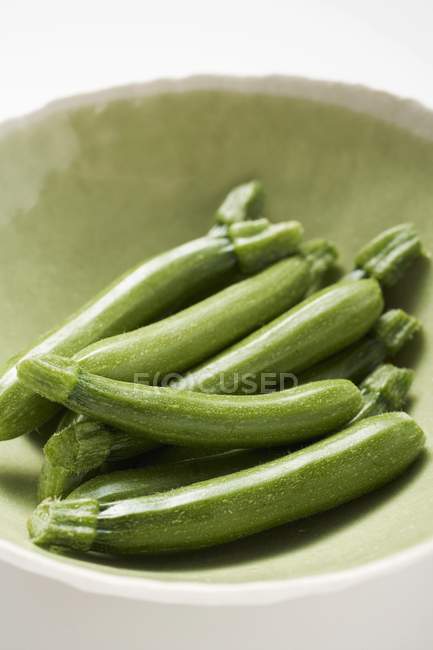 Fresh courgettes in green bowl — Stock Photo