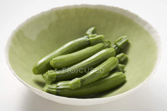 Fresh courgettes in green bowl — Stock Photo