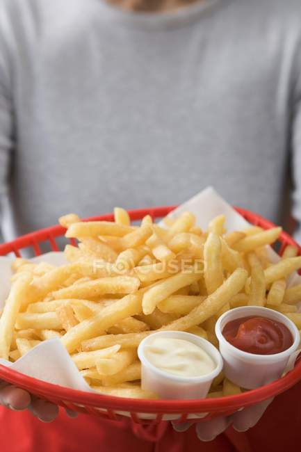 Woman holding basket of fried chips — Stock Photo