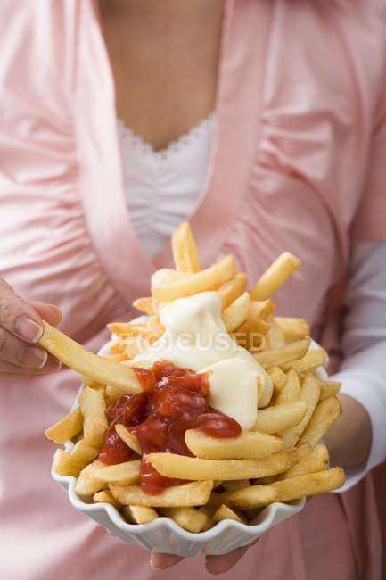 Woman holding paper dish of chips — Stock Photo