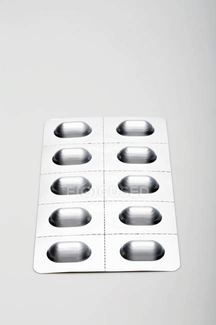Visão de fecho da embalagem blister na superfície branca — Fotografia de Stock
