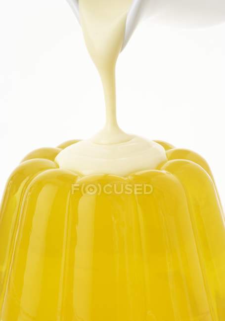 Verter crema sobre gelatina - foto de stock