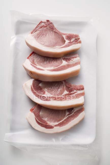 Costeletas de porco cruas em papel — Fotografia de Stock