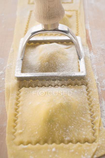 Cutting out homemade ravioli pasta — Stock Photo