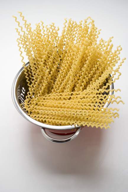Dried Fusilli lunghi pasta in colander — Stock Photo