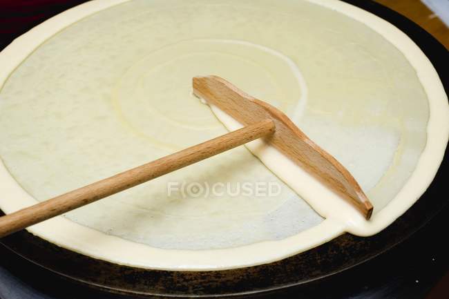 Closeup view of spreading mixture for crepe on hotplate — Stock Photo