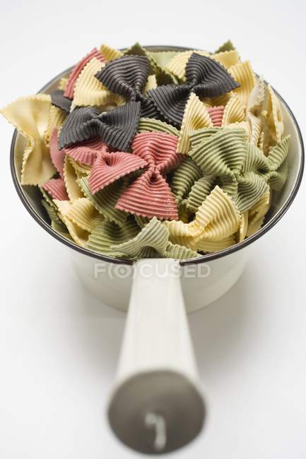 Coloured farfalle pasta in strainer — Stock Photo