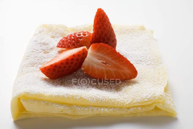 Crepes with icing sugar and strawberries — Stock Photo
