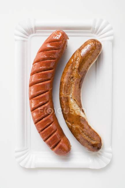 White and red sausages on paper plate — Stock Photo