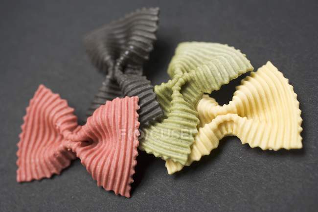 Piezas de pasta farfalle de colores - foto de stock