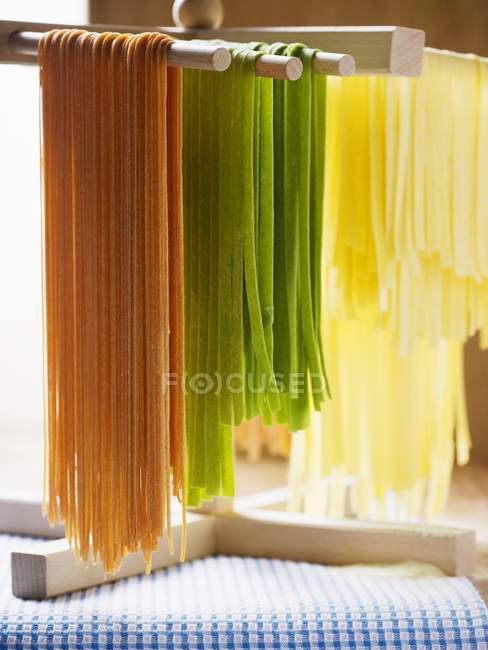 Pastas de colores colgando de palos - foto de stock