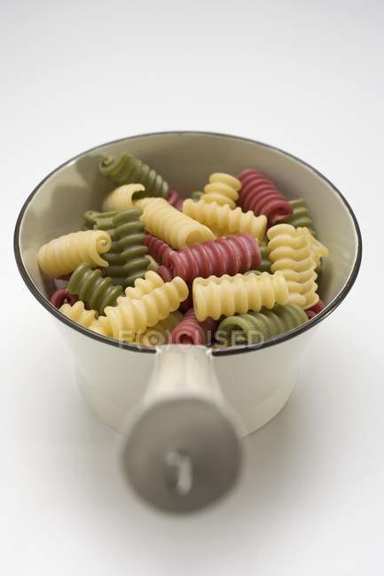 Closeup view of colored Riccioli pasta in metal strainer — Stock Photo