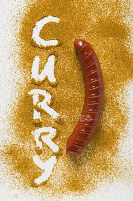 Sausage on curry powder — Stock Photo