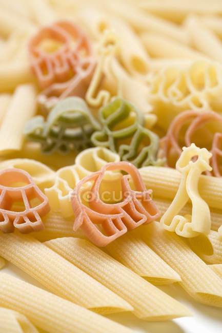 Цветные макароны в форме животных и пенне — стоковое фото