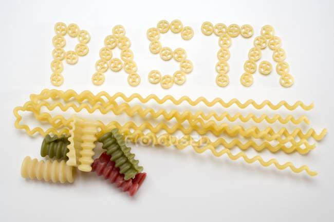 Word Pasta of wheel pasta pieces — Stock Photo