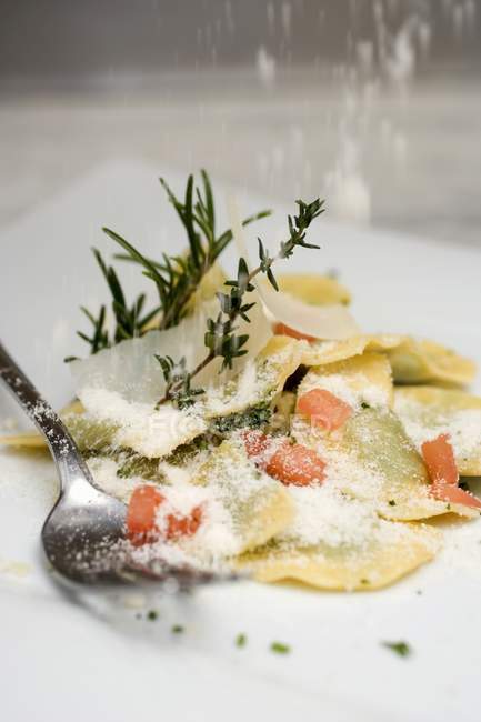 Parmesan Sprinkling onto ravioli pasta — Stock Photo