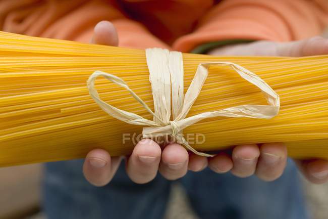 Ребенок держит пачку спагетти — стоковое фото