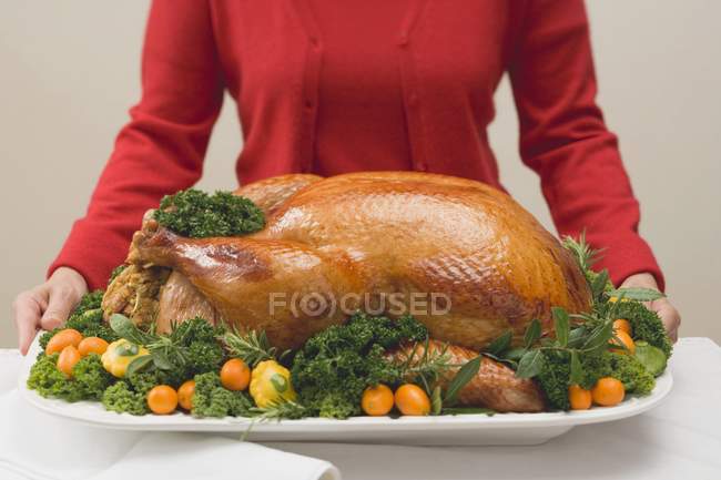 Woman holding roast turkey — Stock Photo