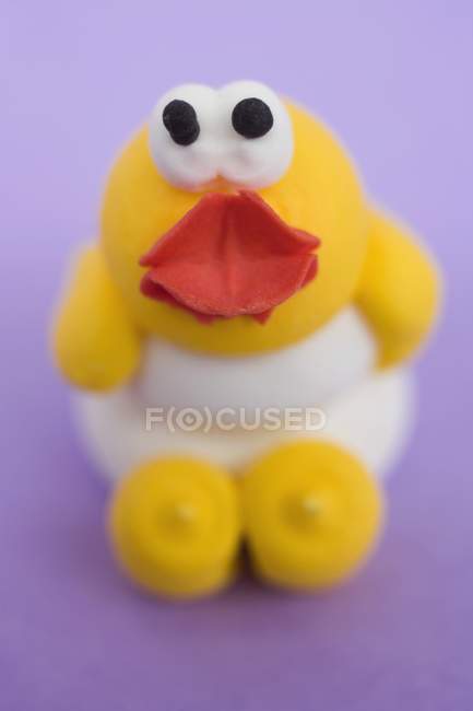 Closeup view of marzipan chick on purple surface — Stock Photo