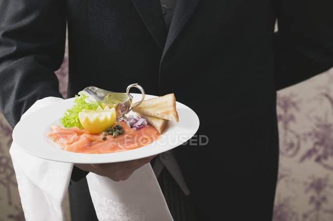 Копченый лосось с тостами на тарелке — стоковое фото