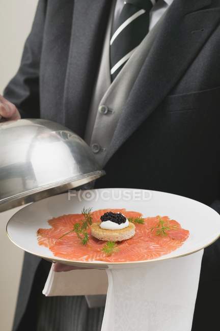 Копченый лосось с икрой на тарелке — стоковое фото