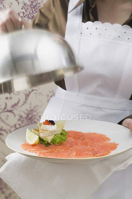 Smoked salmon with toasts on plate — Stock Photo